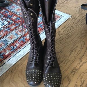 Knee high lace up brown studded boots.